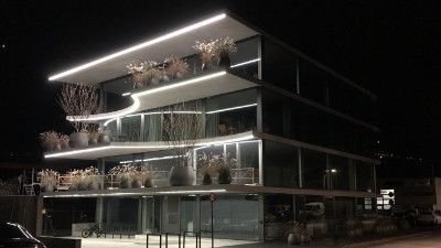 Un grand bâtiment avec de nombreuses fenêtres est éclairé la nuit.