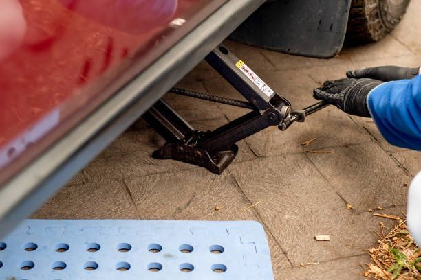 A person is using a jack to lift a car.