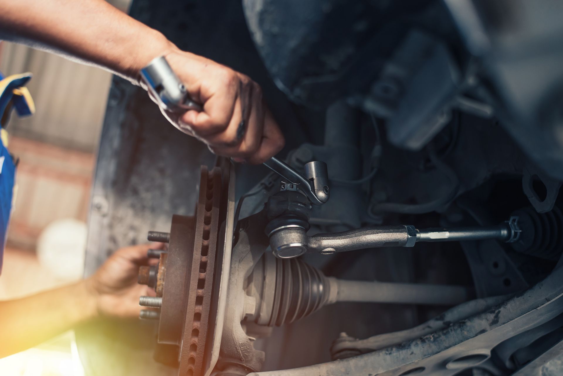 A man is working on a car with a wrench.