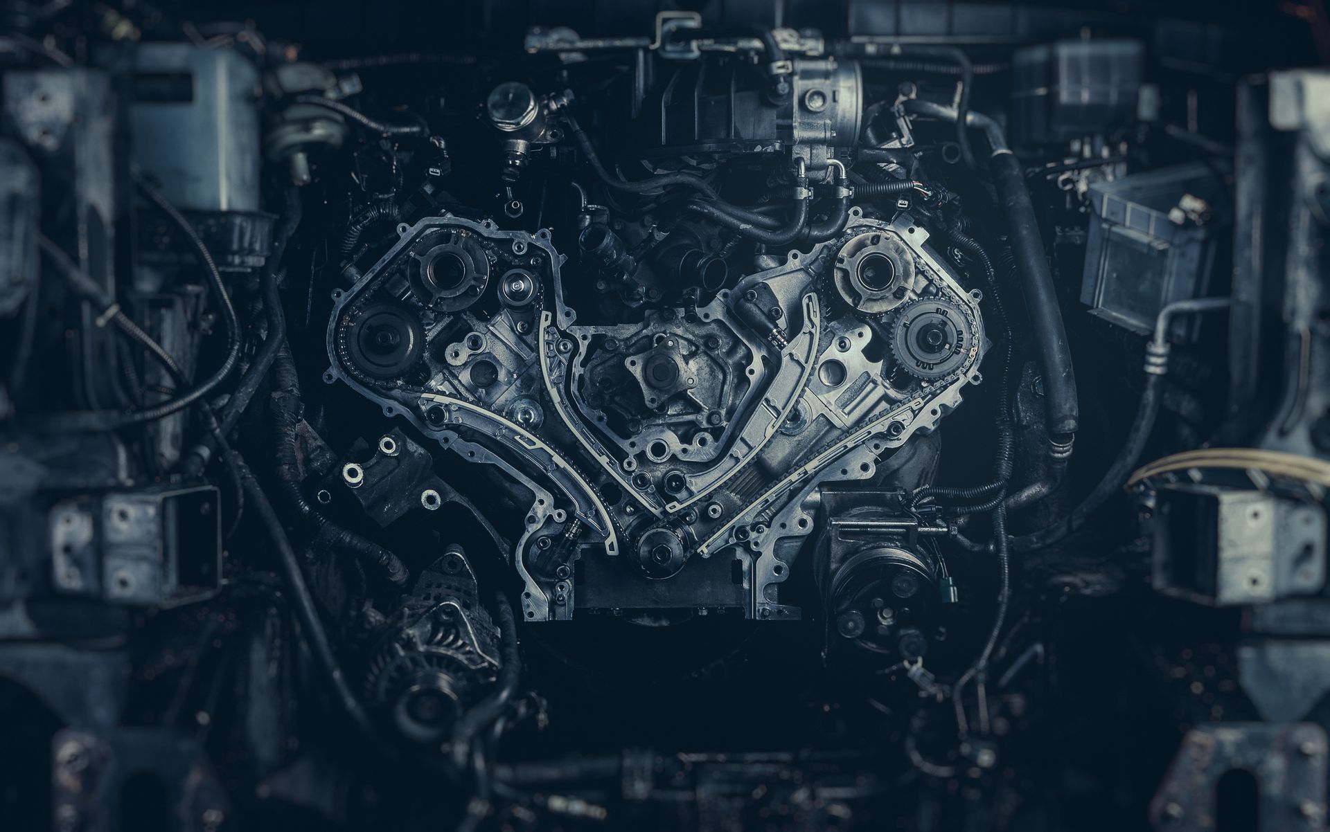 A close up of a car engine in a dark room.