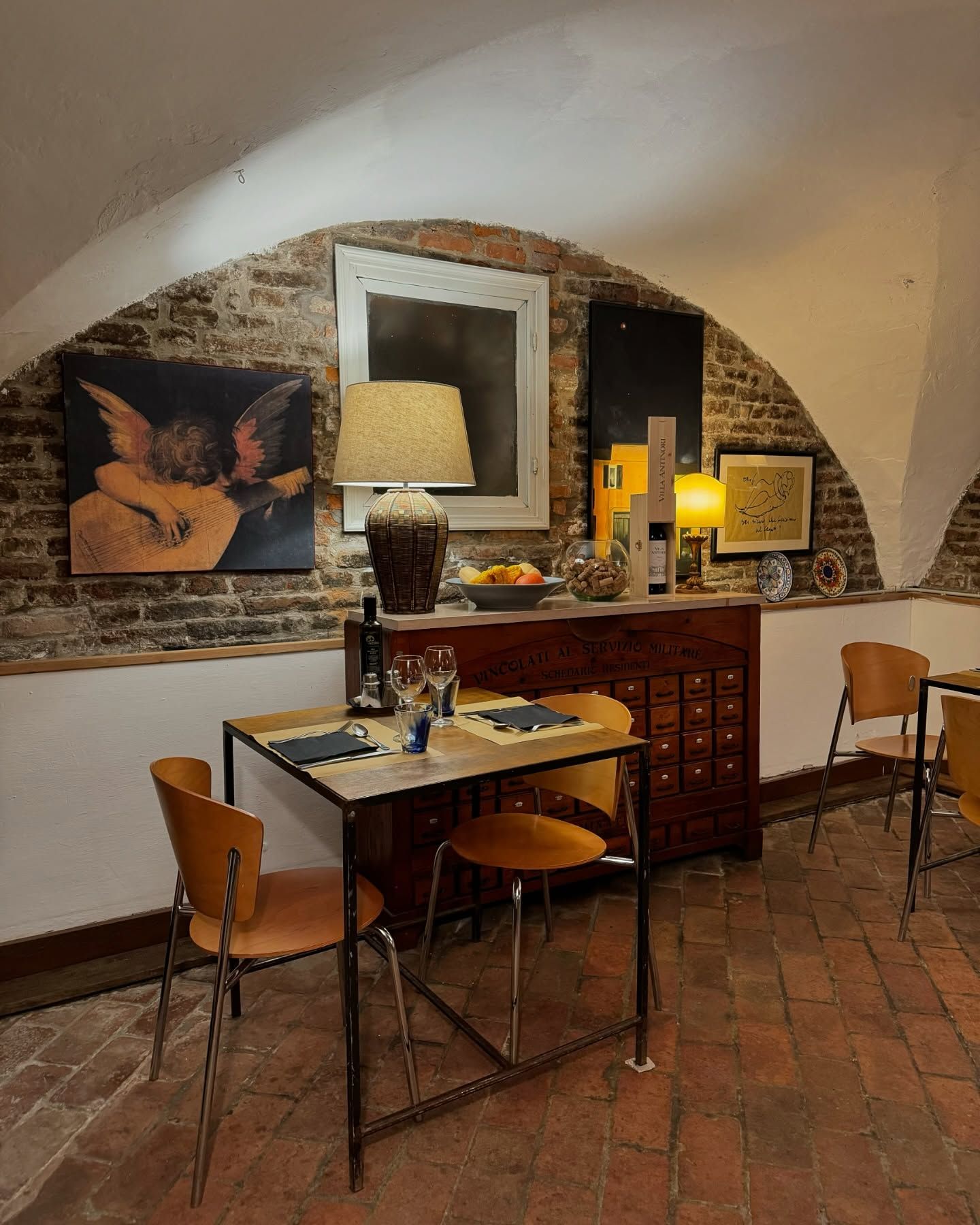 Una stanza con tavoli e sedie e un dipinto sul muro