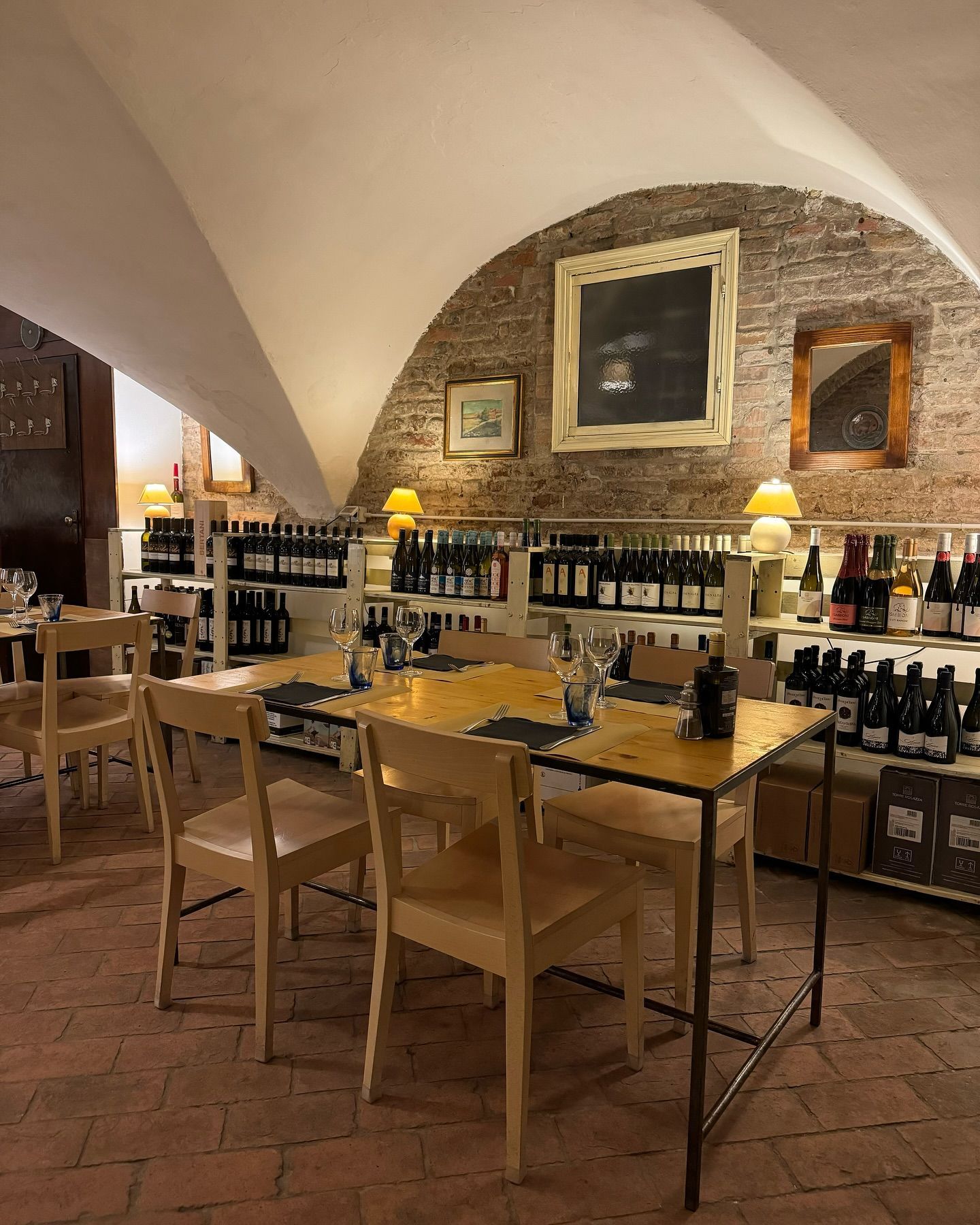 Un ristorante con tavoli, sedie e bottiglie di vino
