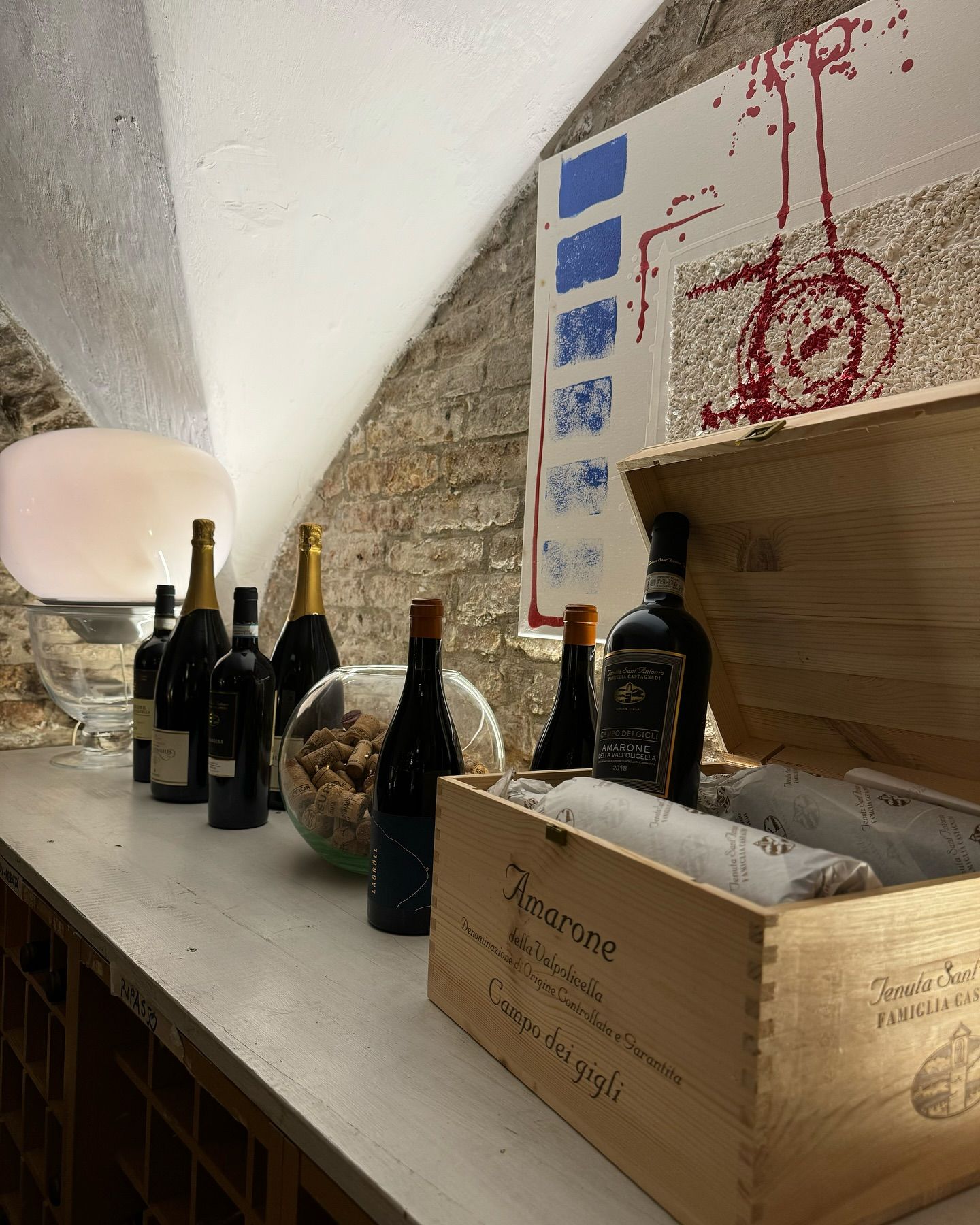 Una scatola di legno piena di bottiglie di vino è appoggiata su un tavolo.