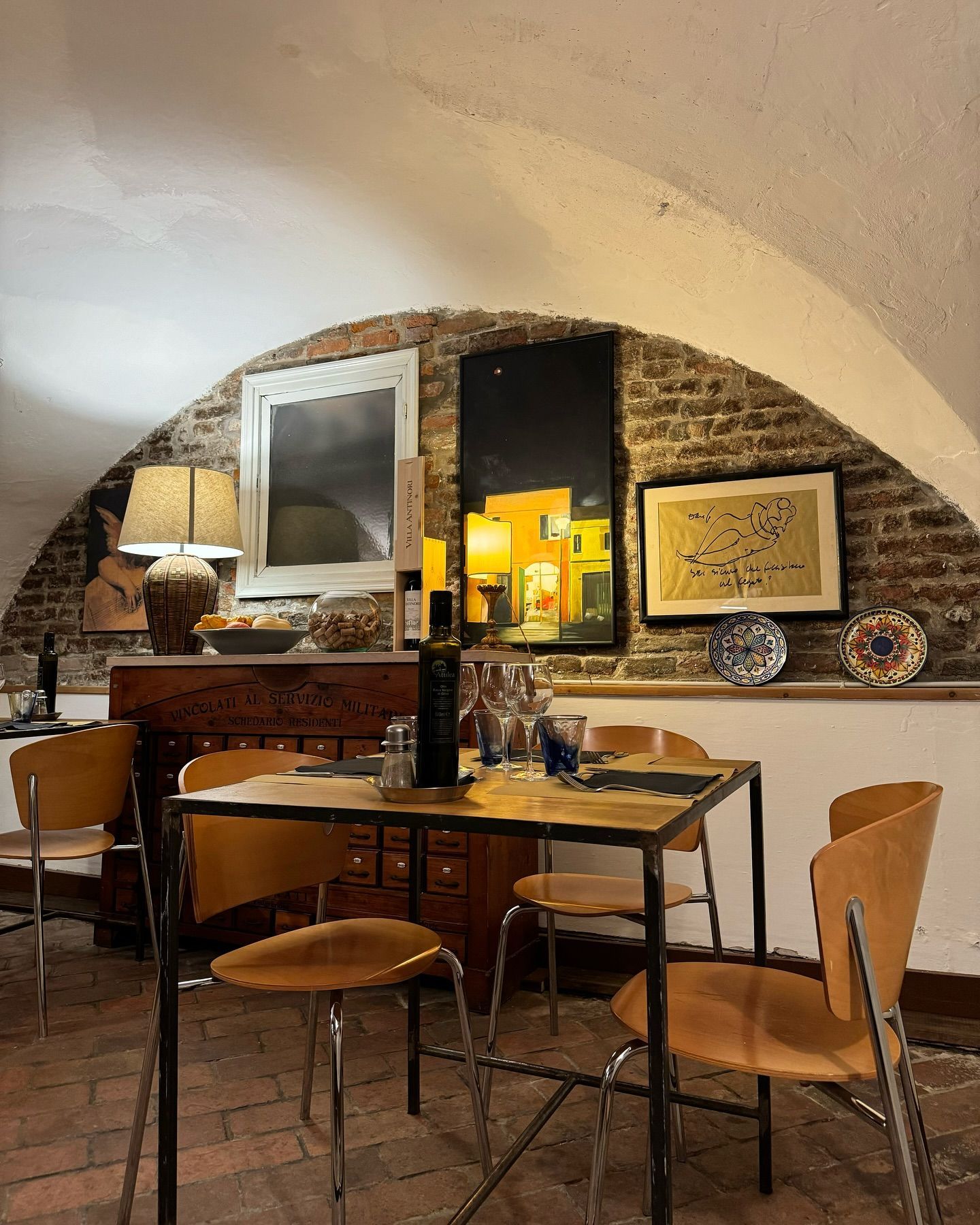 Una sala da pranzo con tavolo e sedie e un muro di mattoni