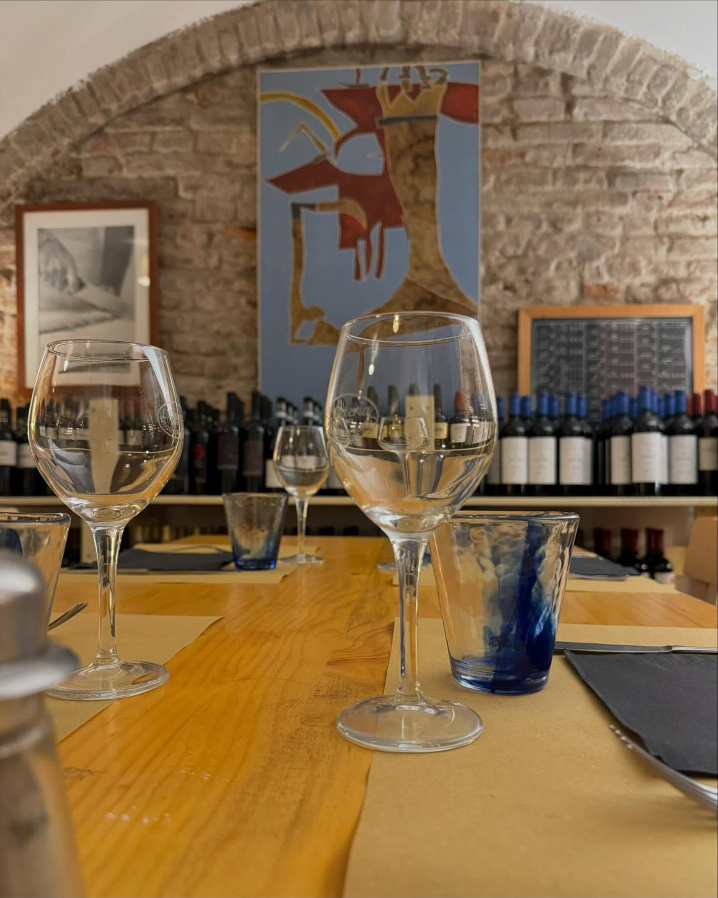 Un tavolo con bicchieri di vino e bottiglie sopra