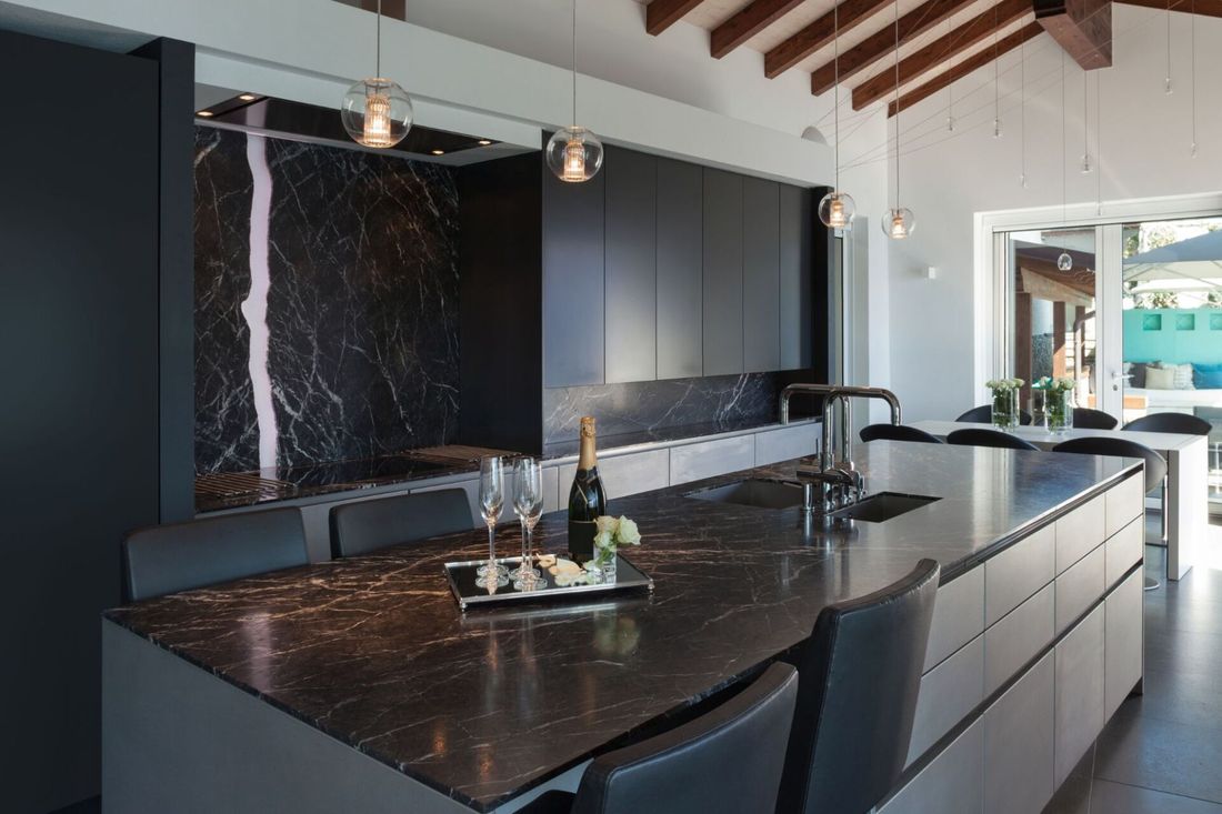 Cucina di design con ripiani e rivestimenti in marmo nero e bianco