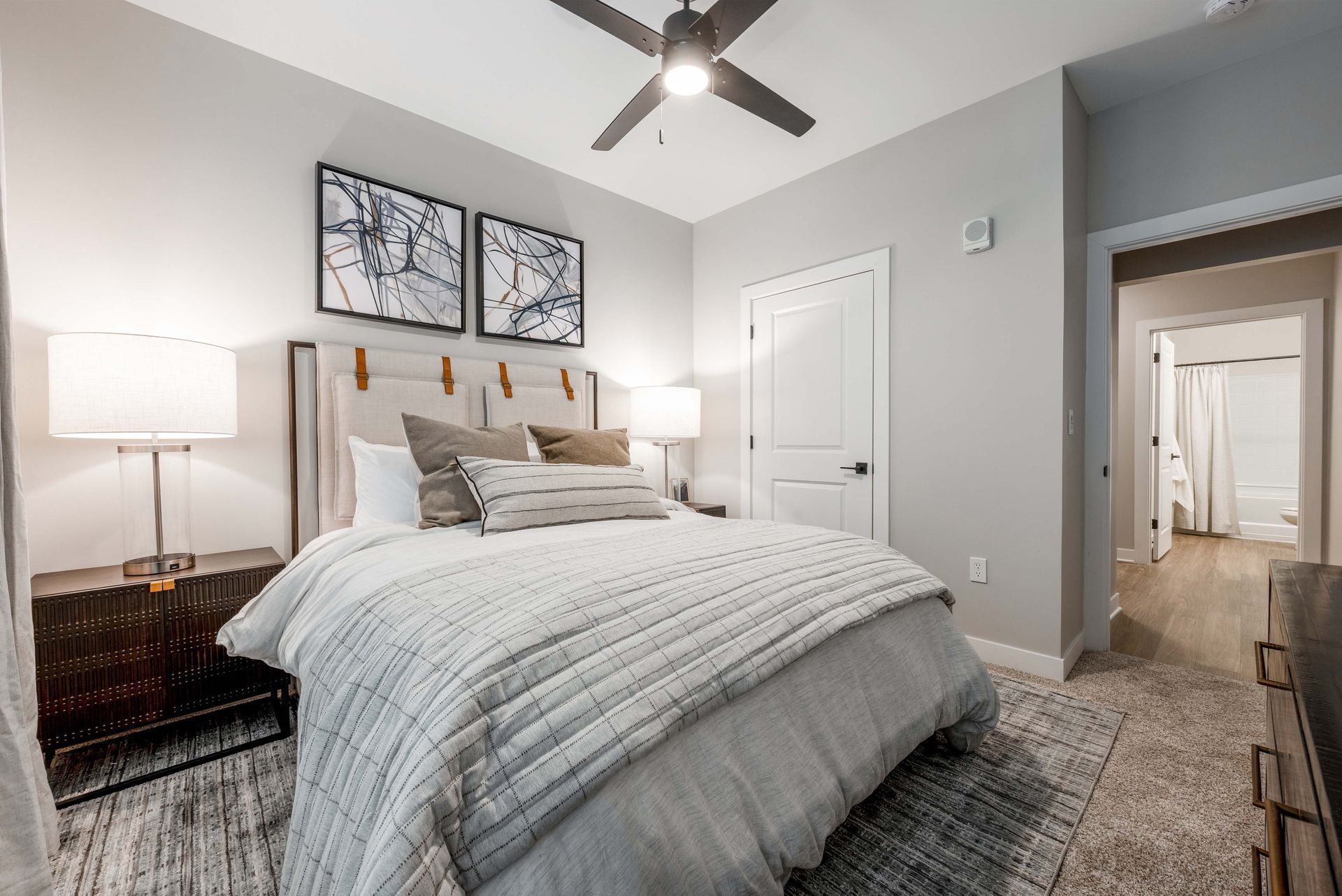 apartment bedroom with ceiling fan and wall art at Federal Hill in Noblesville, IN.