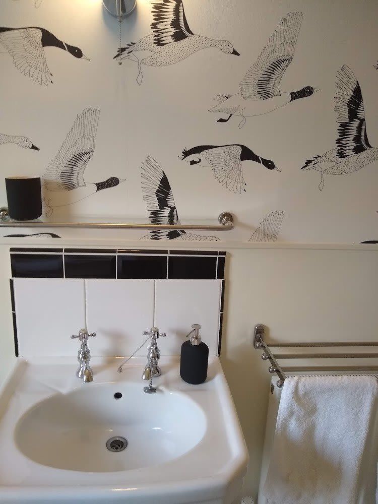 White sink with white and black wall above