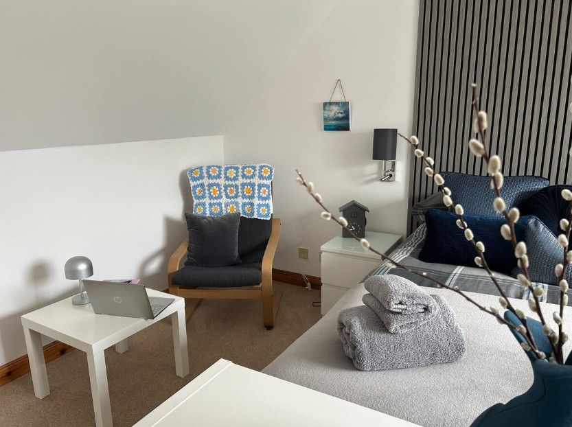 Super-king-size bed with folded towels and dressing table on one side