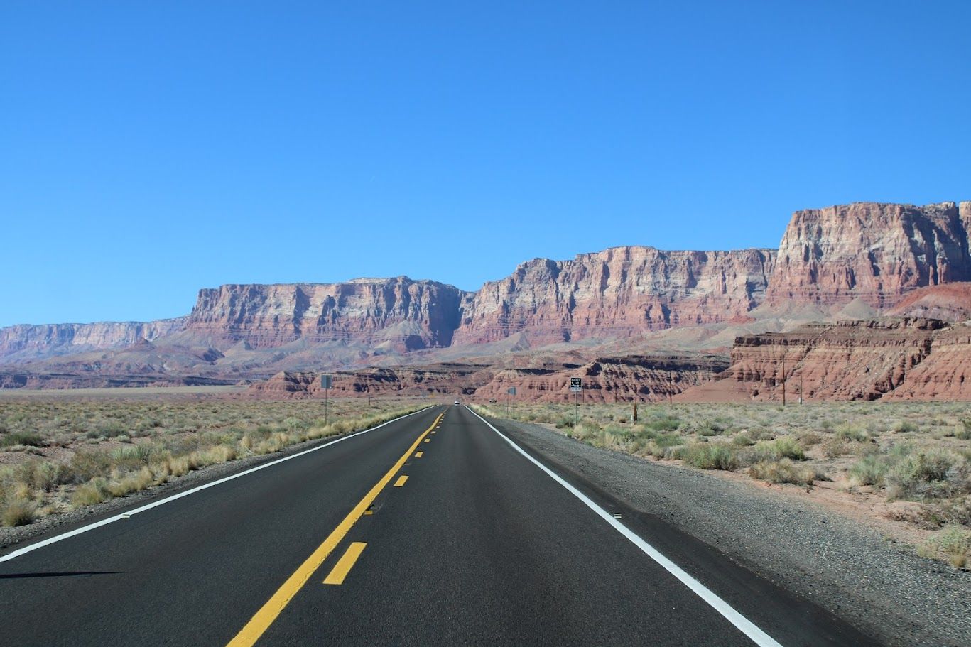 A road in the desert with mountains in the background