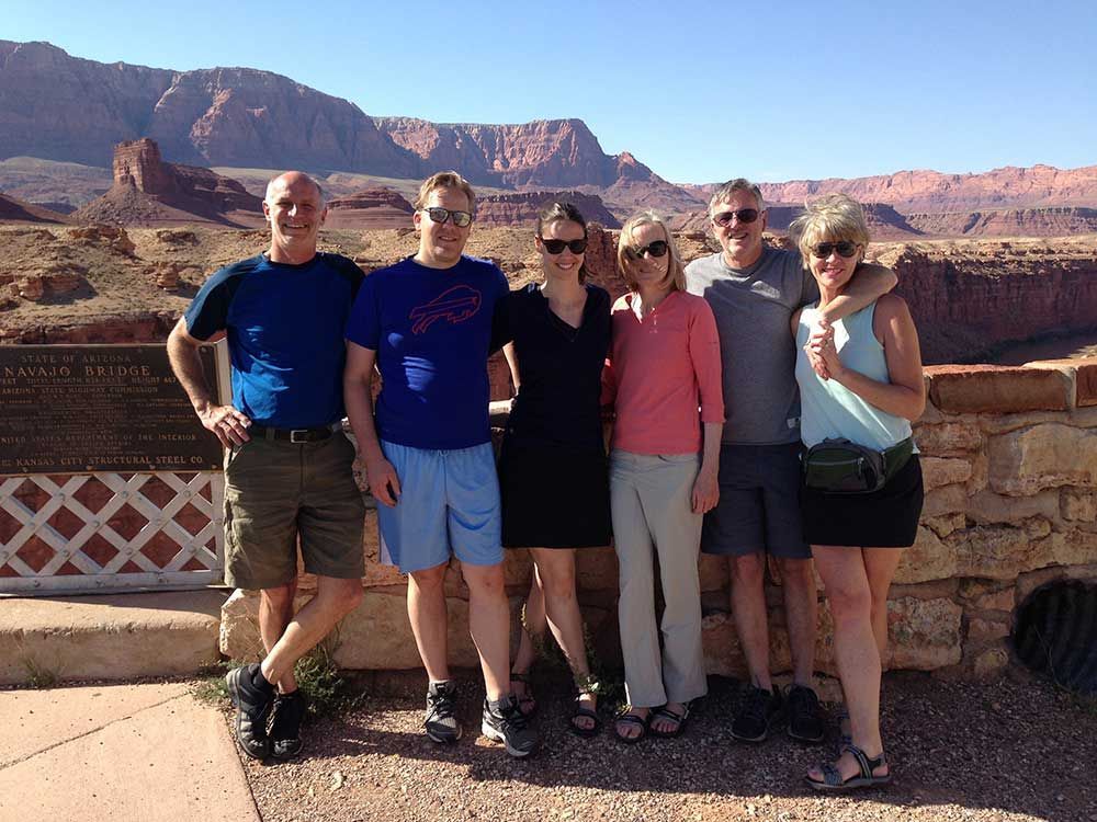 A group of people posing for a picture with mountains in the background