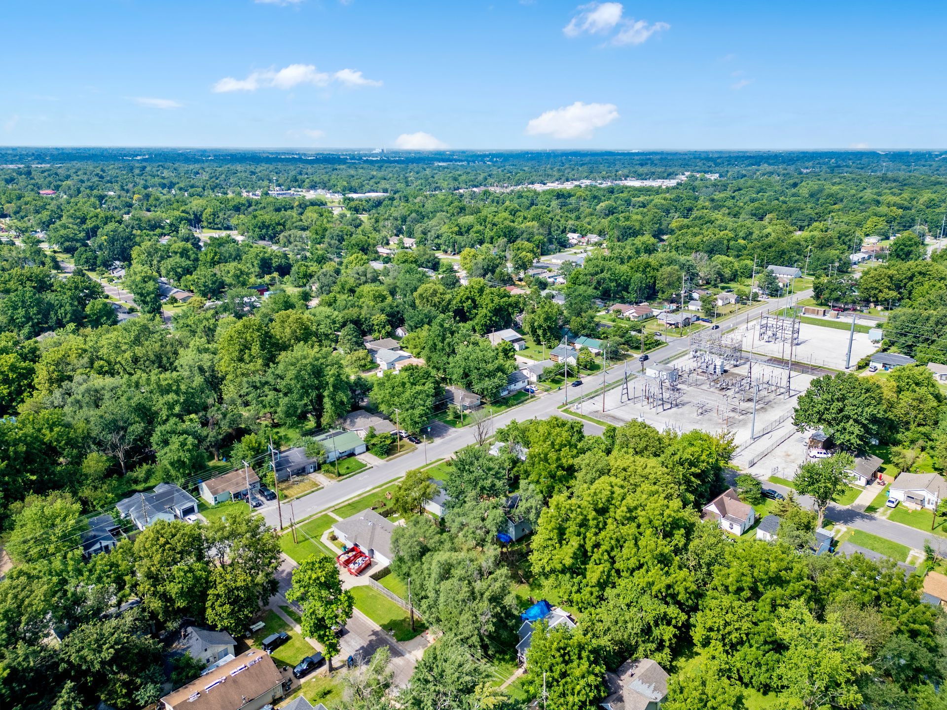 A vast green forest landscape under a cloudy sky.