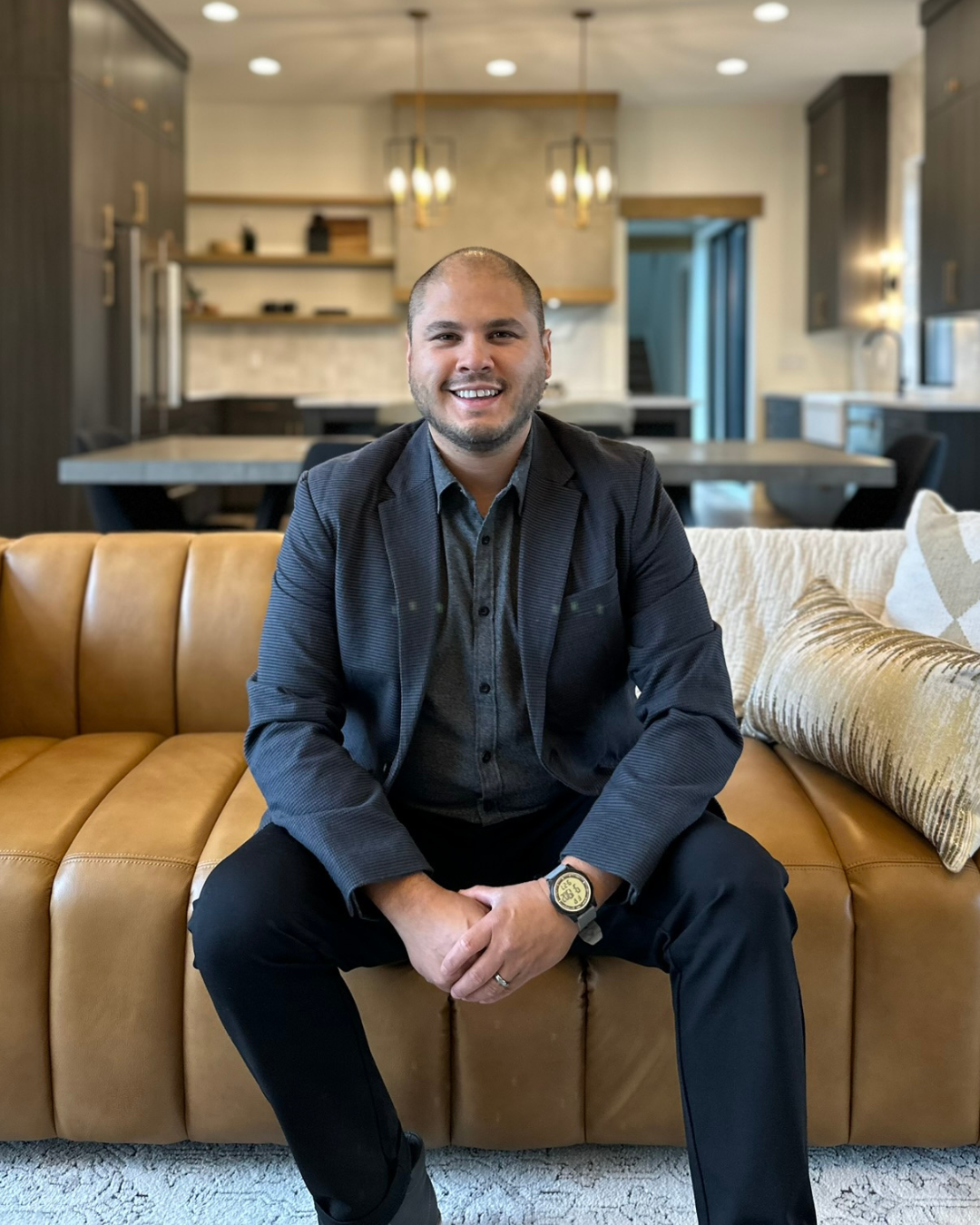 Man in blue blazer, smiling, holding a document, standing outside.