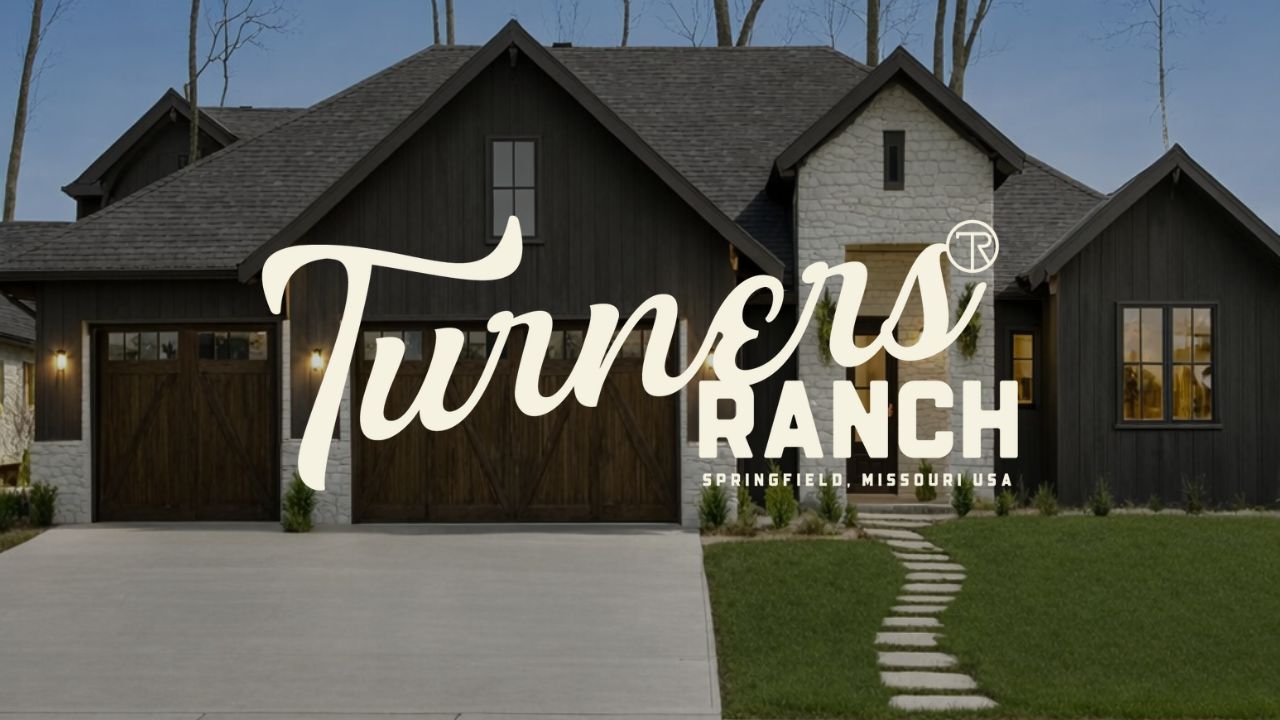 Brick building with a bright red door, black shutters, and white window shutters. Stone steps lead up to the entrance.