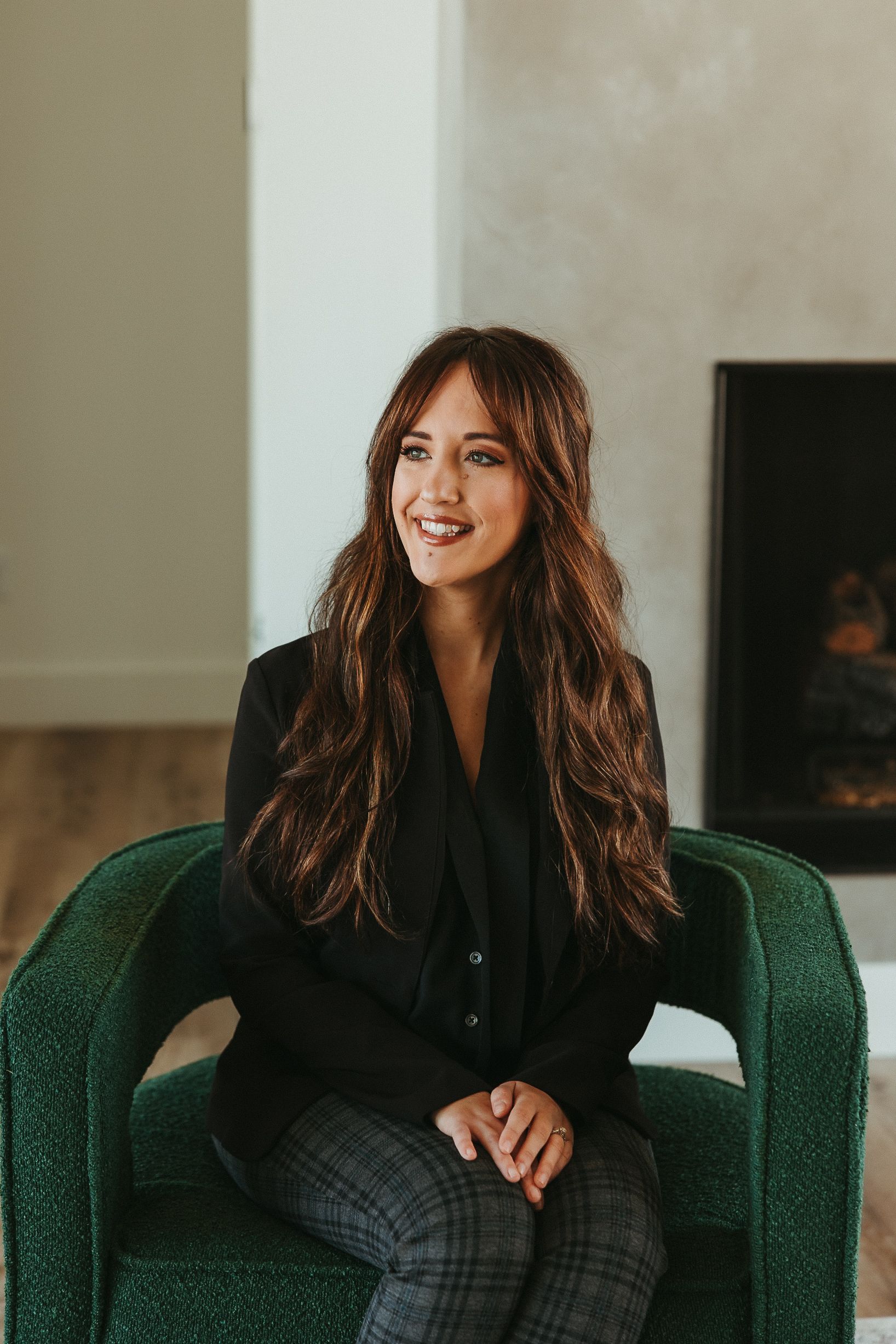 Aerial view of a suburban neighborhood with houses, streets, trees, and a golf course. Sunny day with clouds.