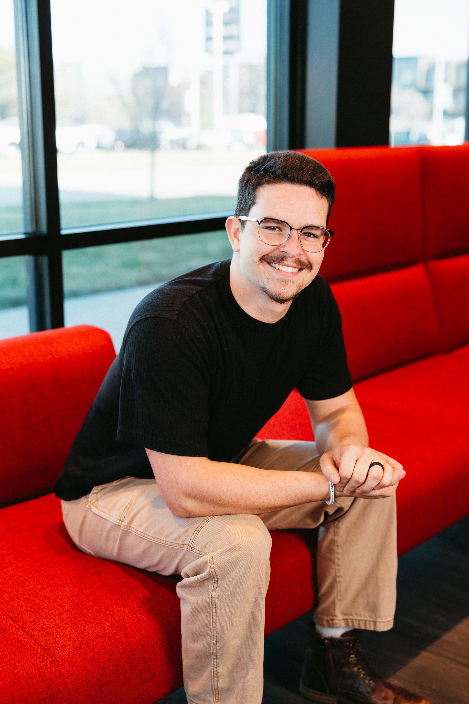 Bright kitchen with island, white cabinets, stainless steel appliances, and wooden flooring.
