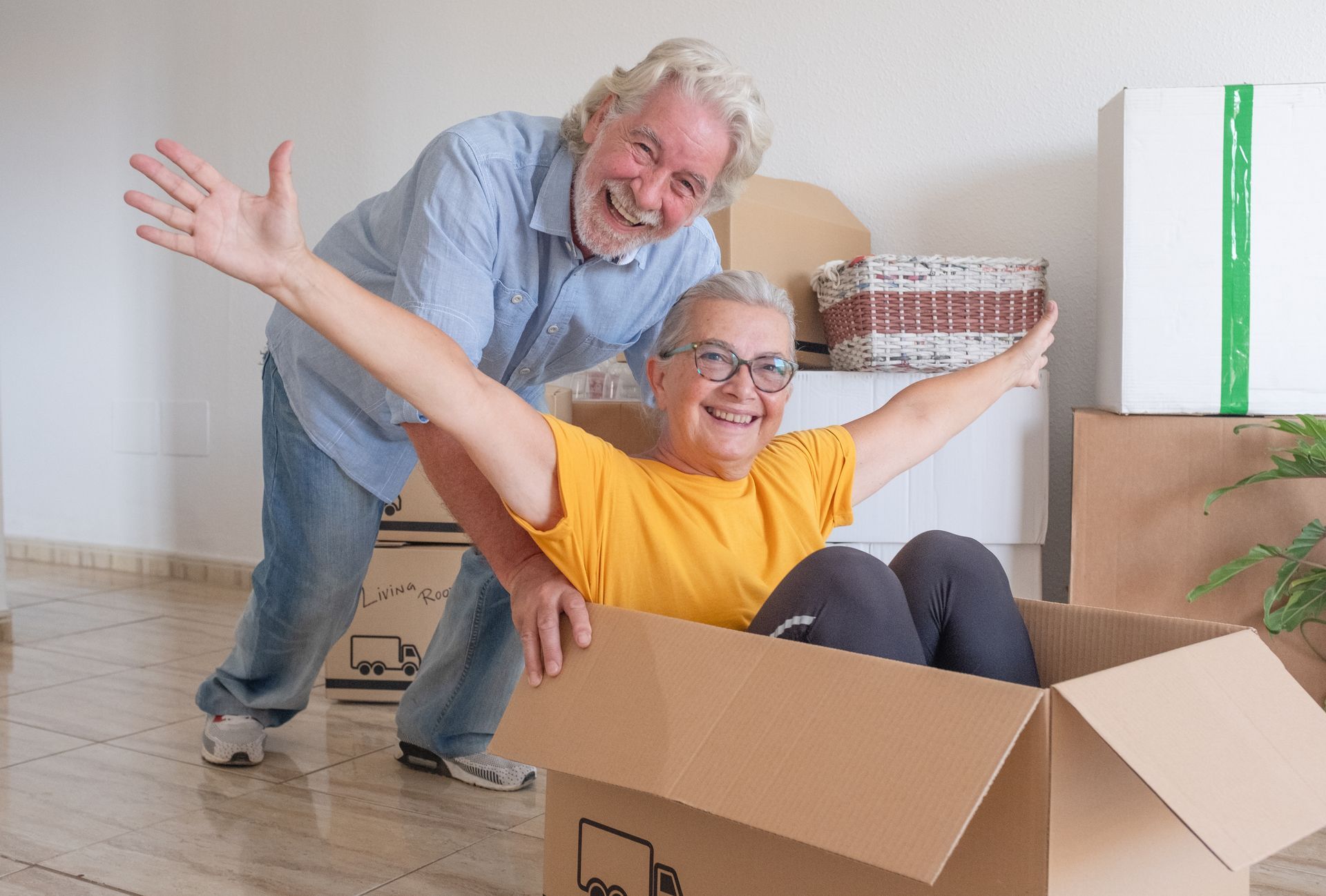 Older couple celebrating downsizing into a new home in Springfield MO with moving boxes around them