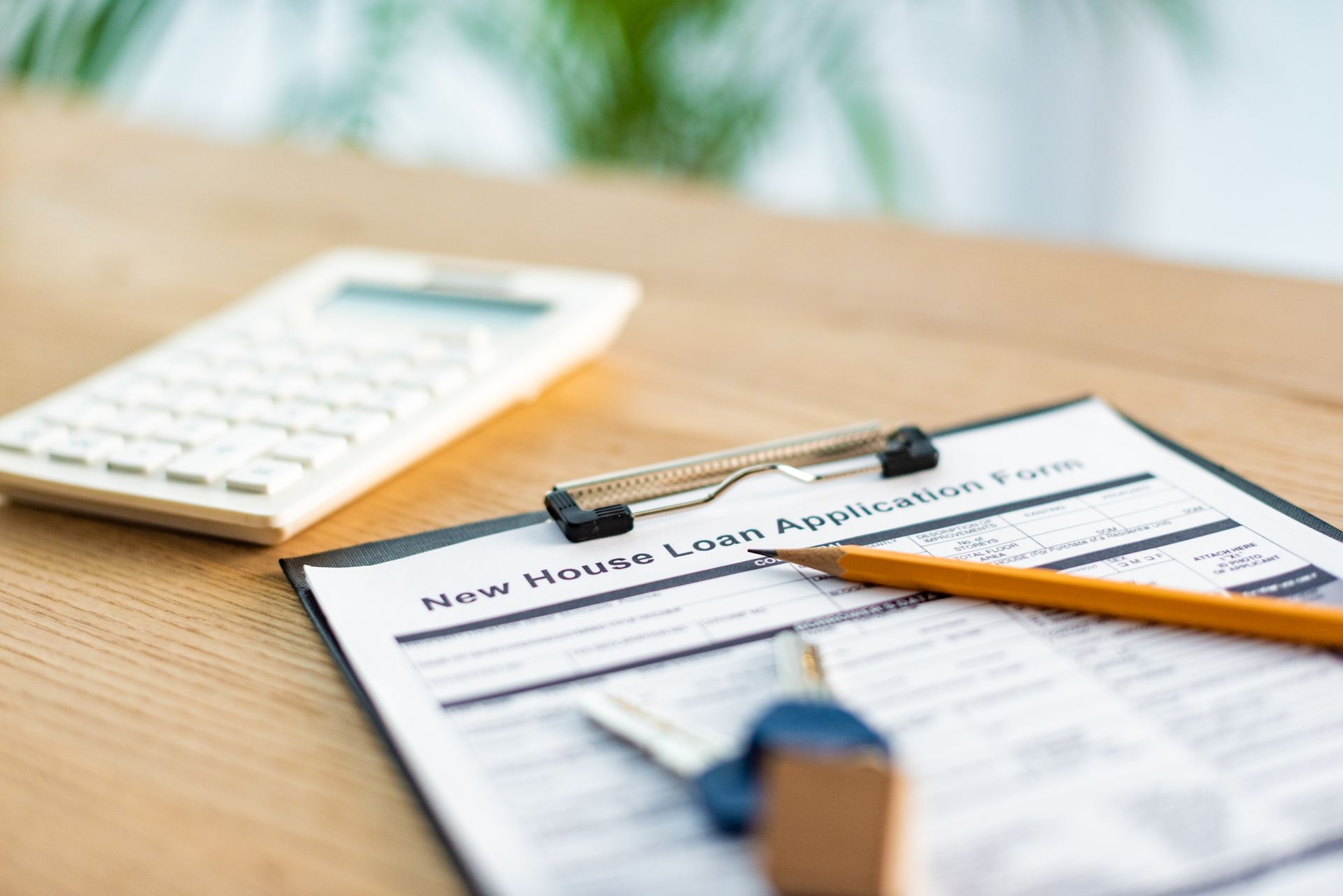 Home sale paperwork with calculator and keys showing costs and taxes when selling a house