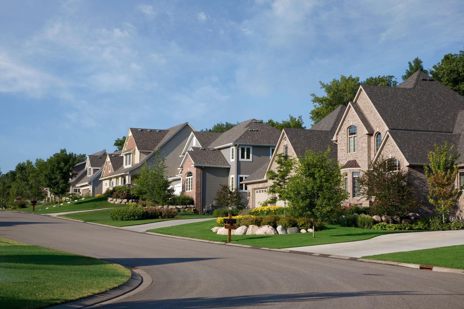 Upscale homes along a landscaped residential street in Springfield, Missouri.