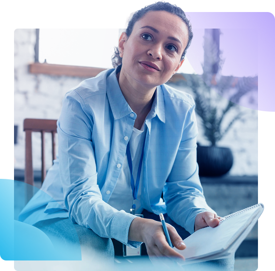 Woman in a blue shirt taking notes in a bright office setting
