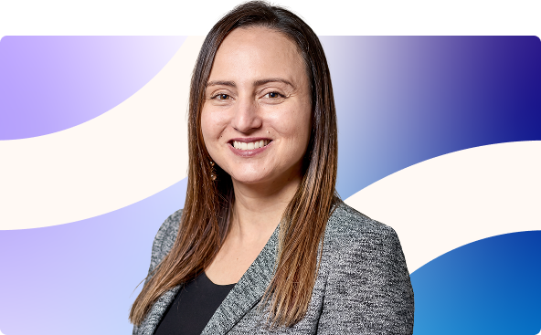 Smiling woman with long hair in a gray blazer against a purple and blue abstract background