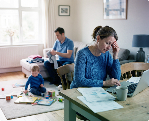 Man using a laptop at a desk by a window, with a coffee mug and small plant nearby