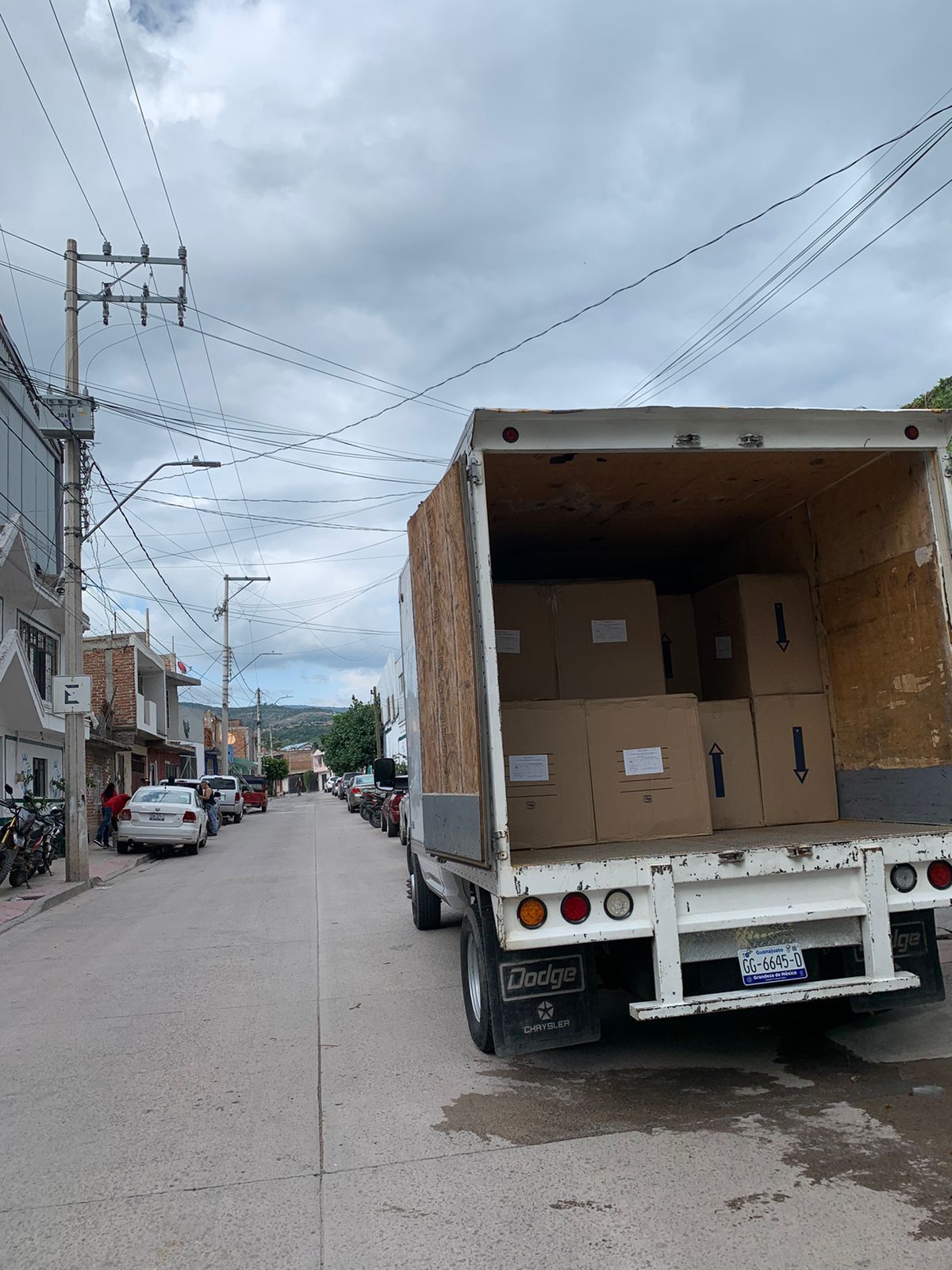 Un camión está estacionado al costado de la carretera con cajas en la parte trasera.ubicacion