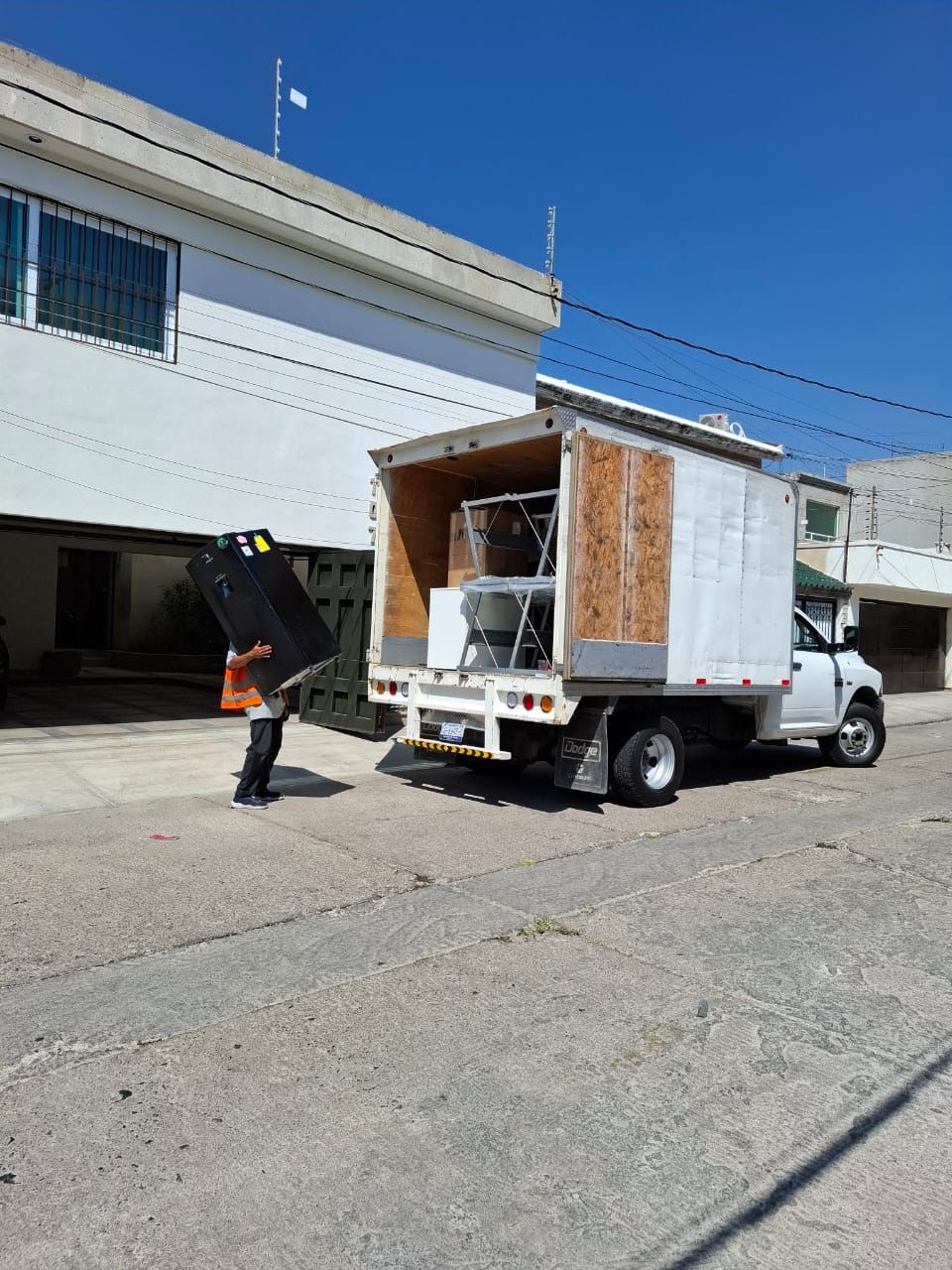 Un hombre está cargando un refrigerador en un camión de mudanzas.