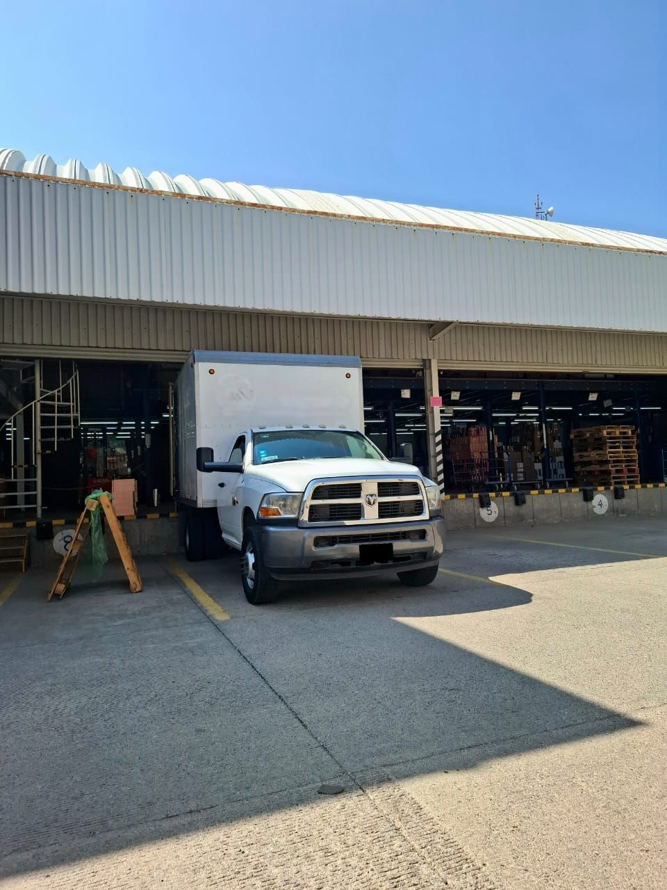 Un camión blanco está estacionado frente a un edificio.