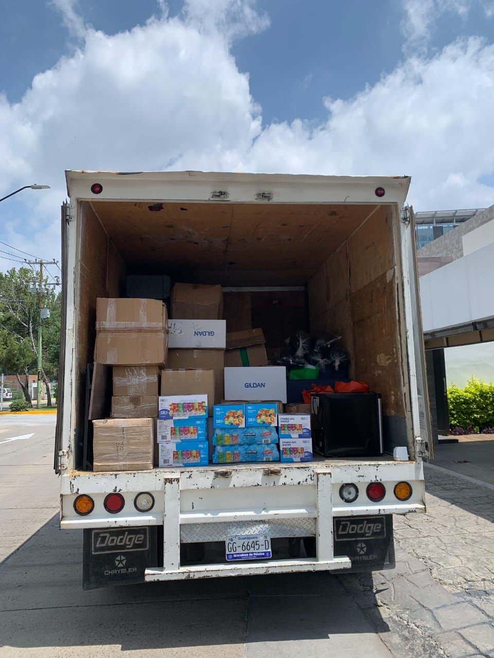 La parte trasera de un camión de carga está llena de cajas.