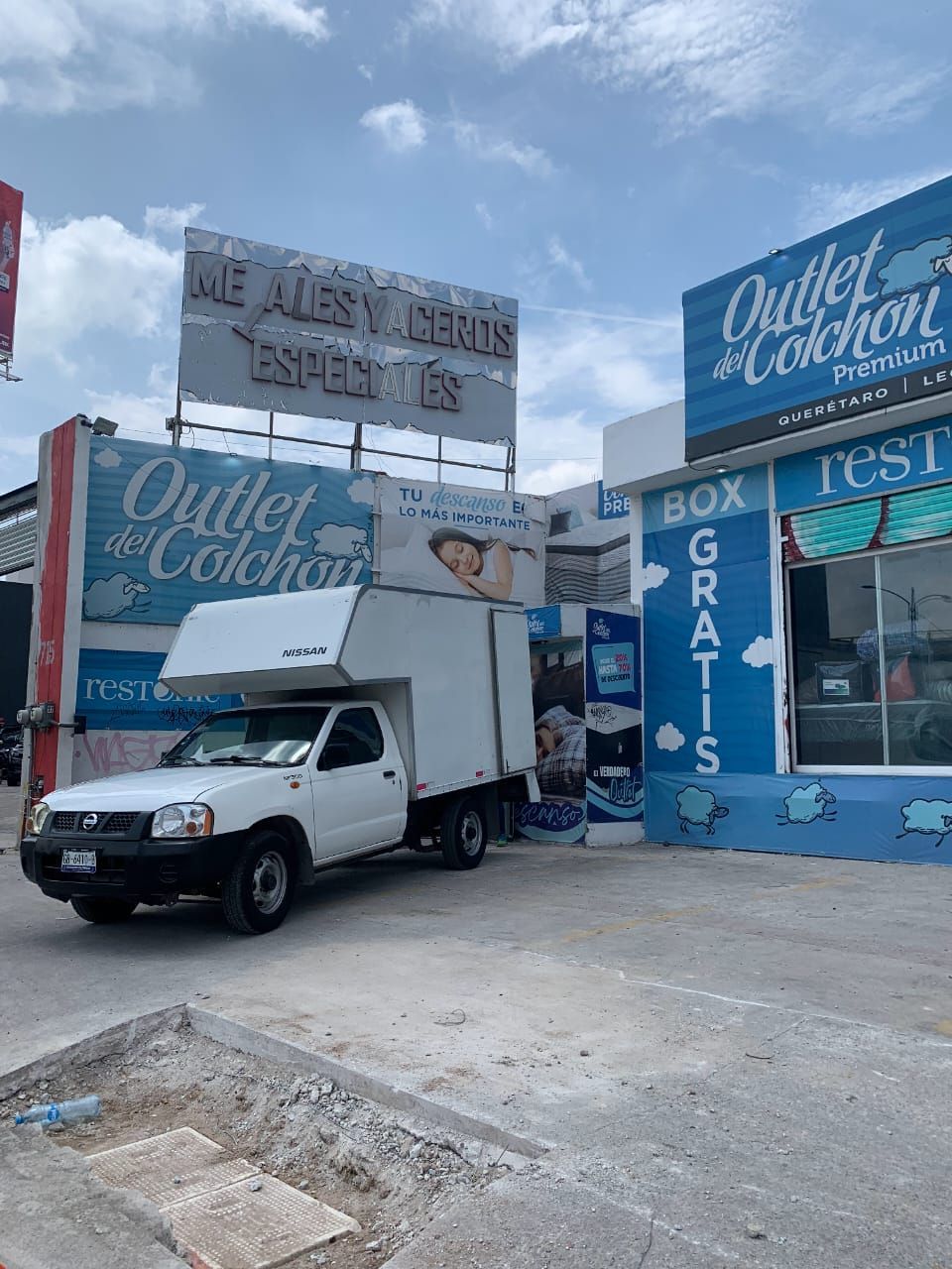 Un camión blanco está estacionado frente a una tienda.