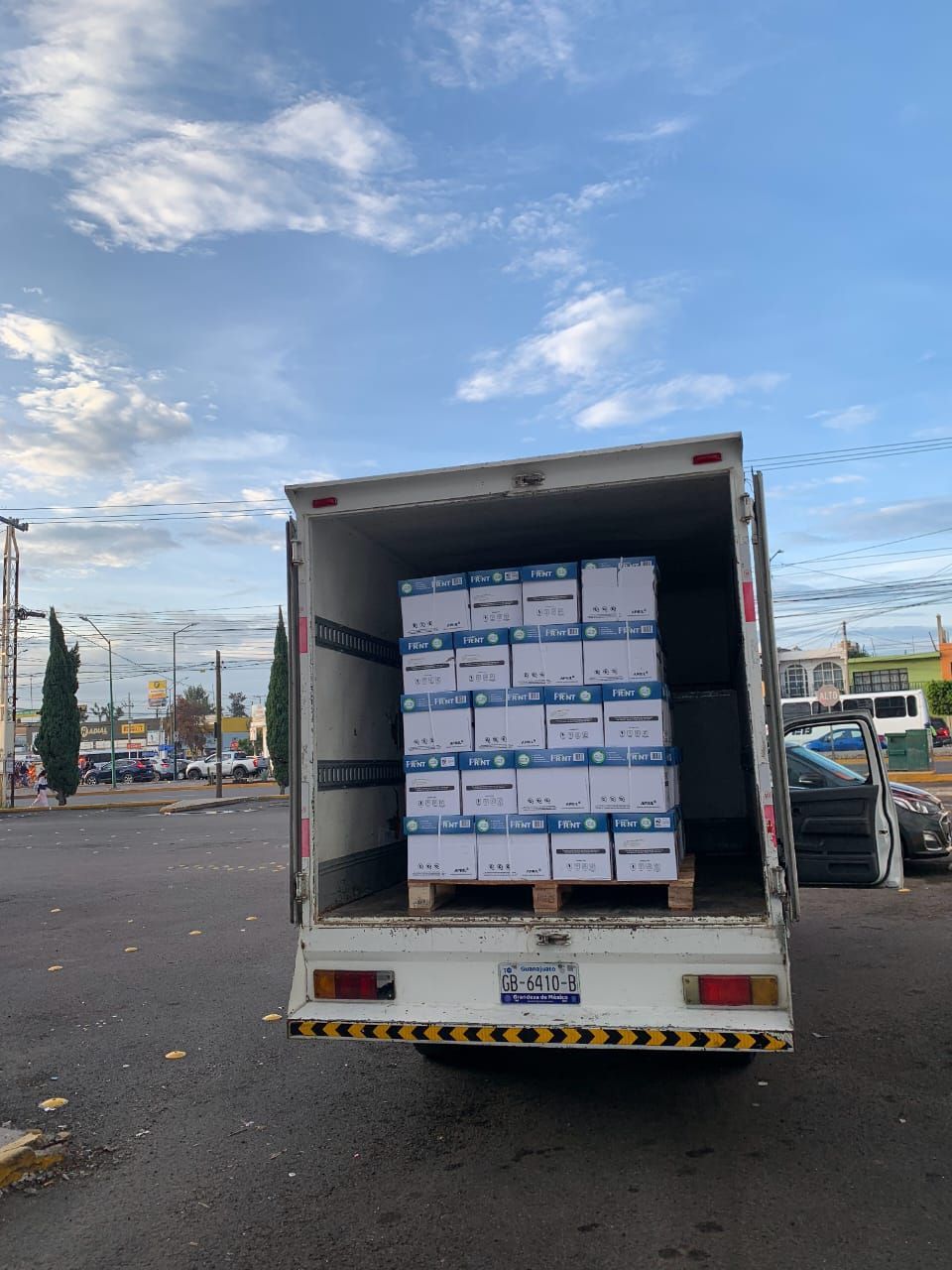 Un camión blanco está cargado con cajas de papel.