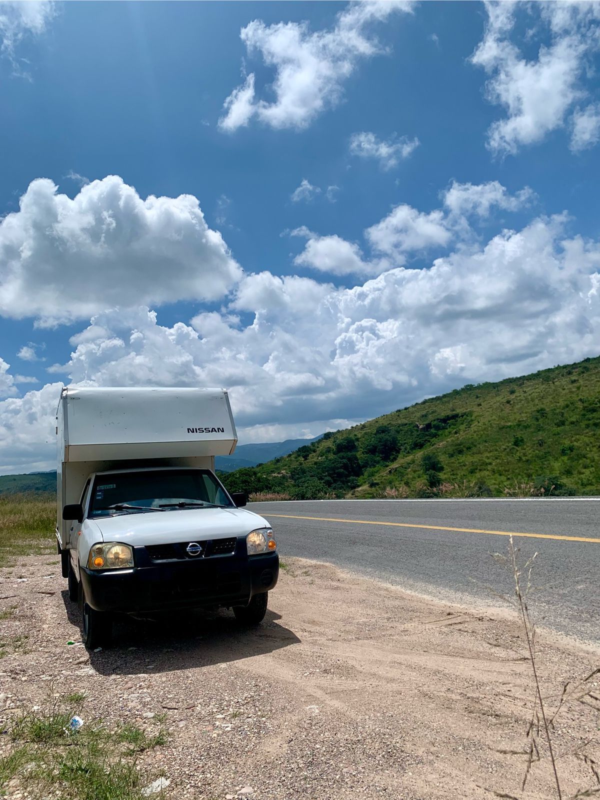 Un camión blanco está estacionado al costado de la carretera.
