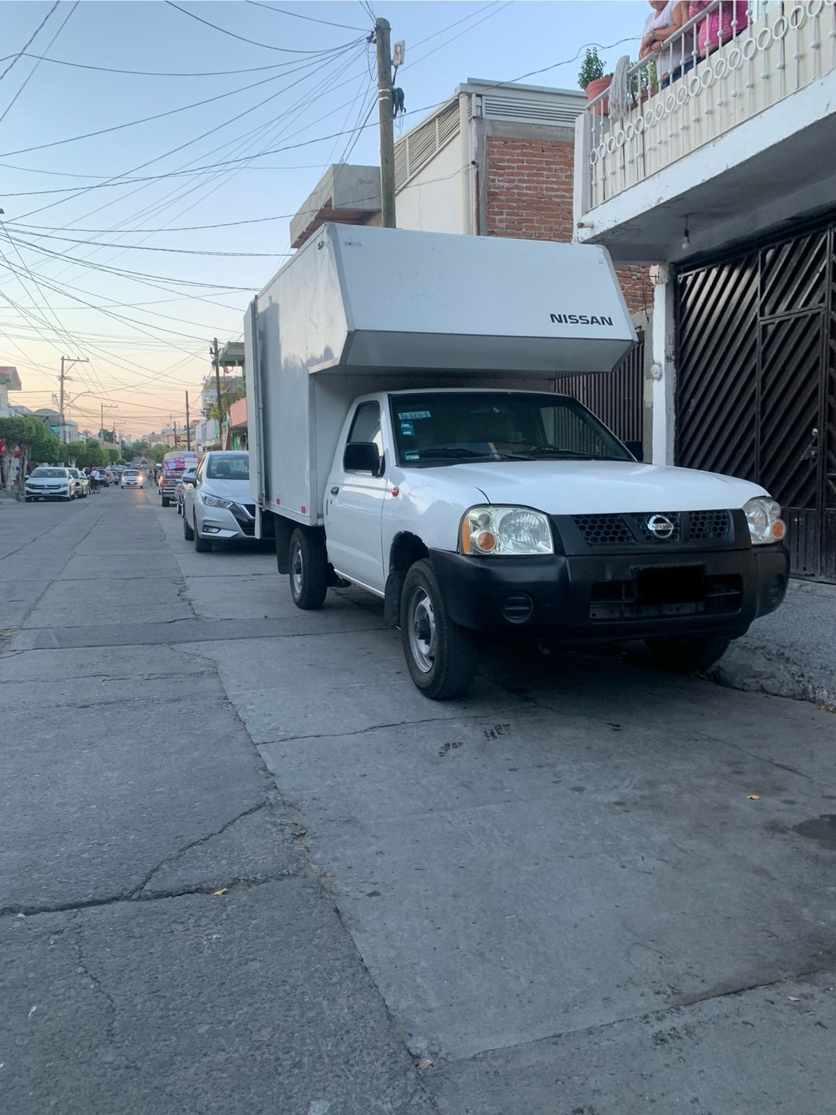 Un camión blanco está estacionado al costado de la carretera.