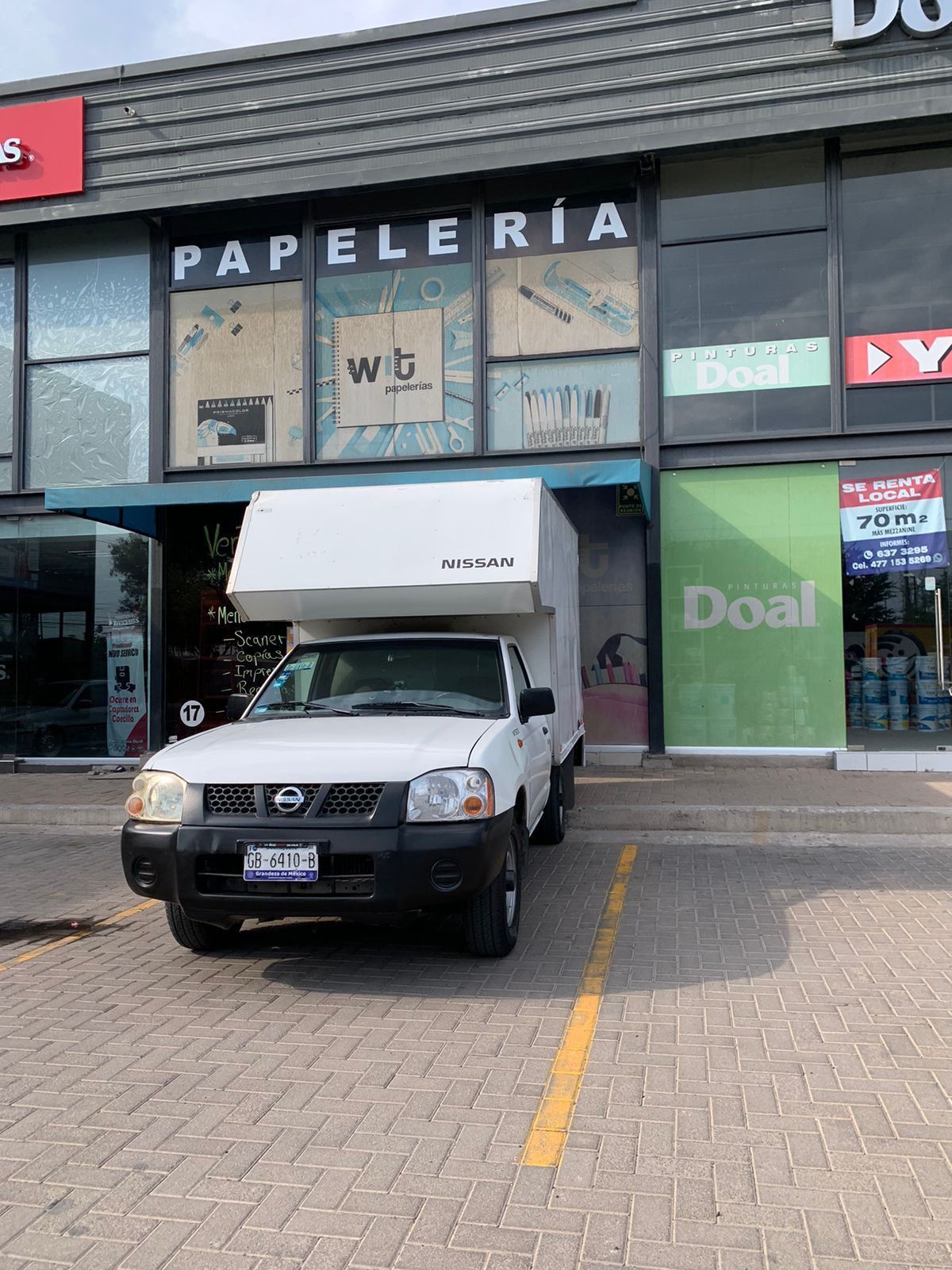 Un camión blanco está estacionado frente a un edificio.