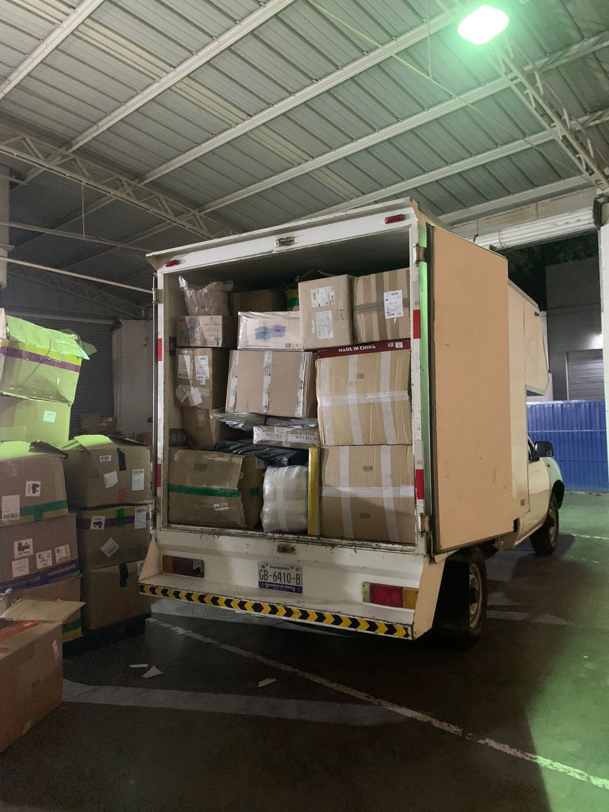Un camión lleno de cajas está estacionado en un almacén.