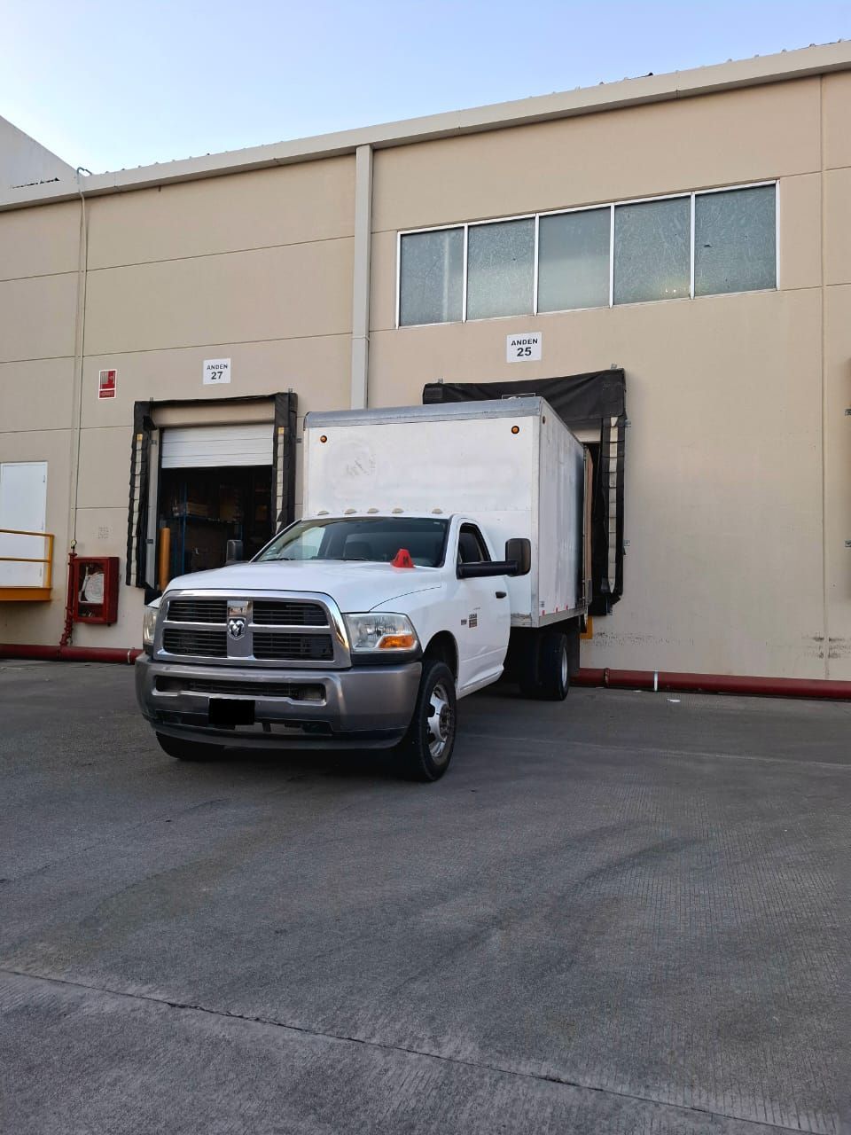 Un camión blanco está estacionado frente a un edificio.