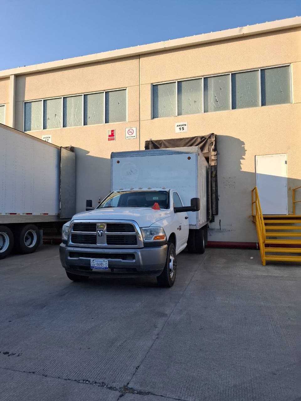 Un camión blanco está estacionado frente a un edificio.