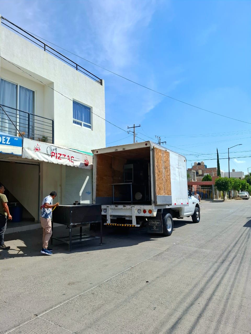 Un camión blanco está estacionado al costado de la carretera.