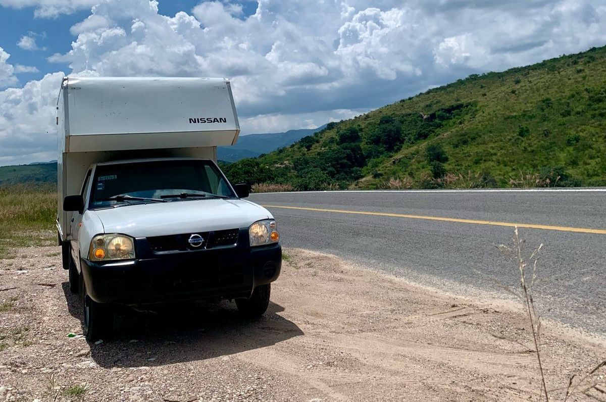 Un camión blanco está estacionado al costado de la carretera.