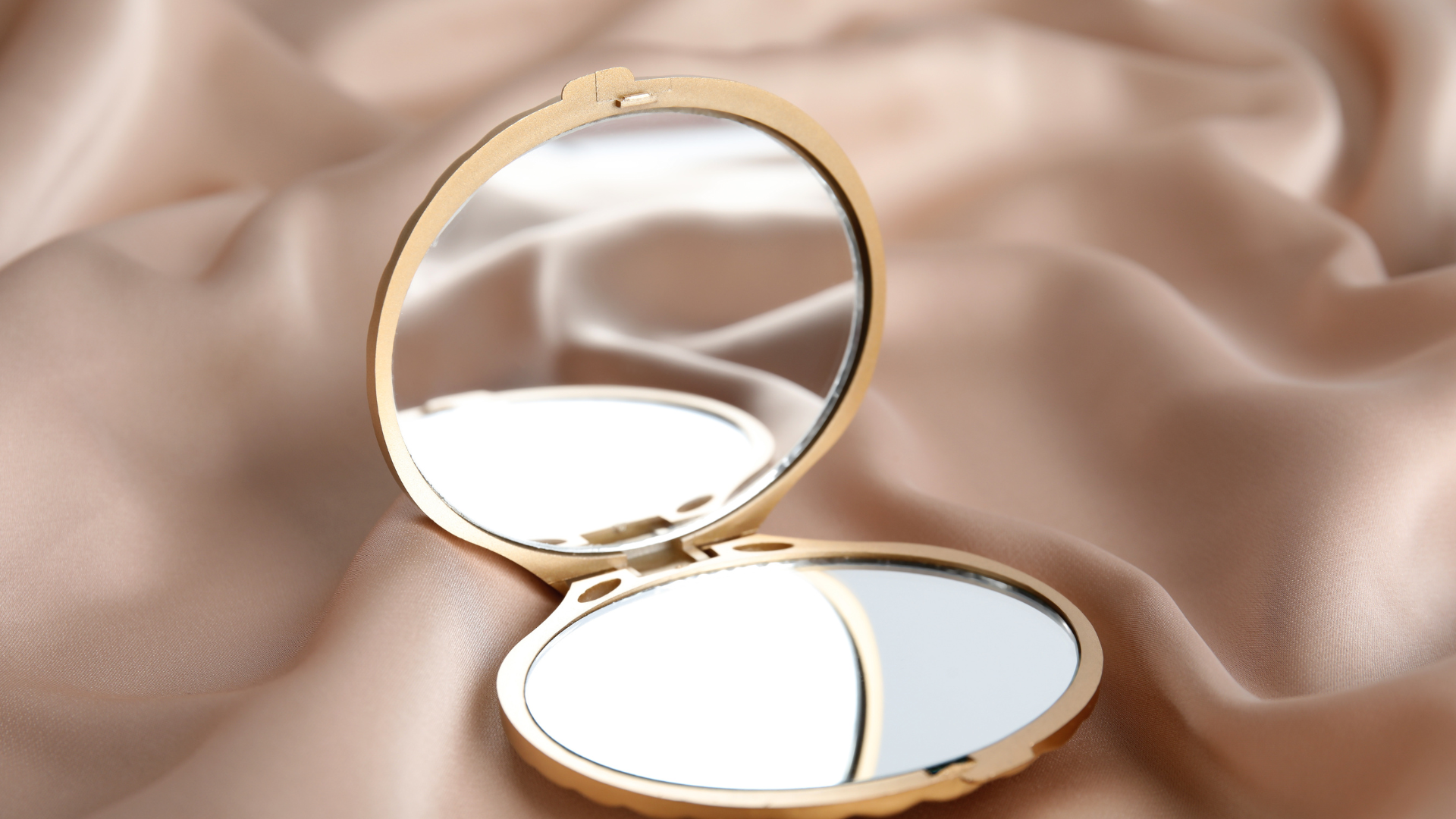 A round mirror is sitting on a piece of cloth.