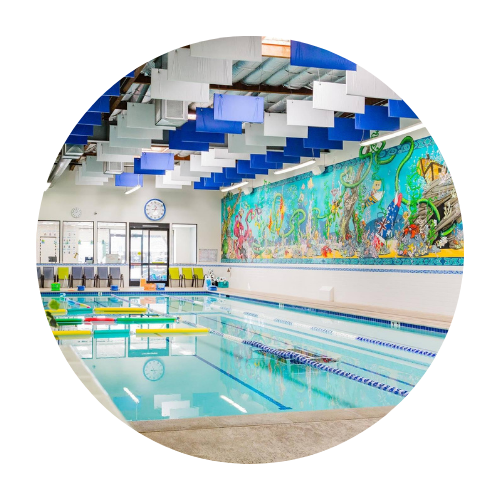 A large indoor swimming pool with a mural on the wall