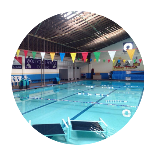 A swimming pool with a woodcroft school sign on the wall