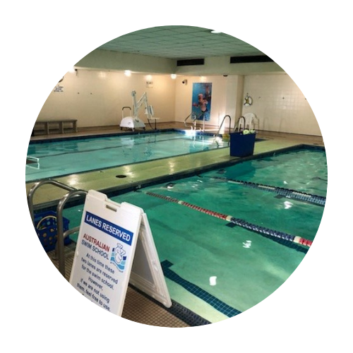 A large indoor swimming pool with a sign that says lines reserved.