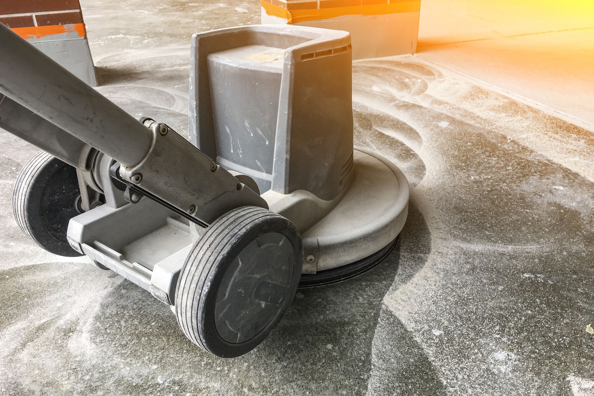 A machine is cleaning a concrete floor in a building.