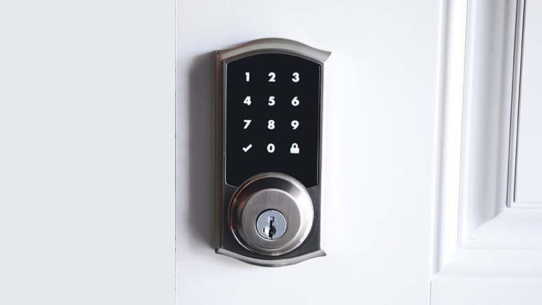 A close up of a digital door lock on a white door.