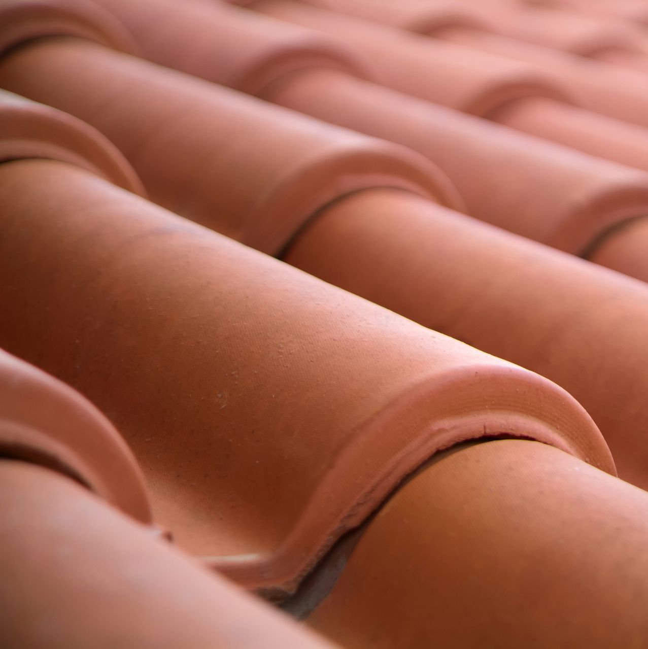 A close up of a row of red tiles on a roof