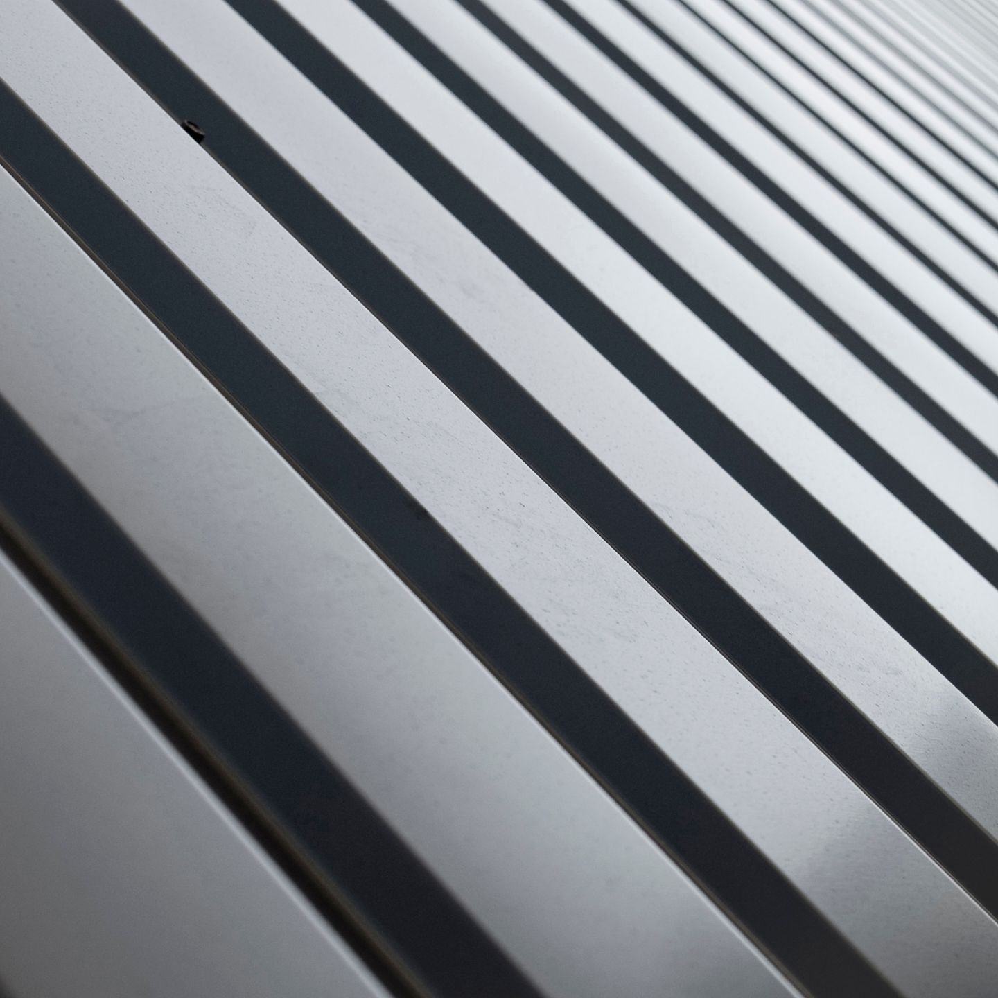 A close up of a metal roof with a diagonal striped pattern.