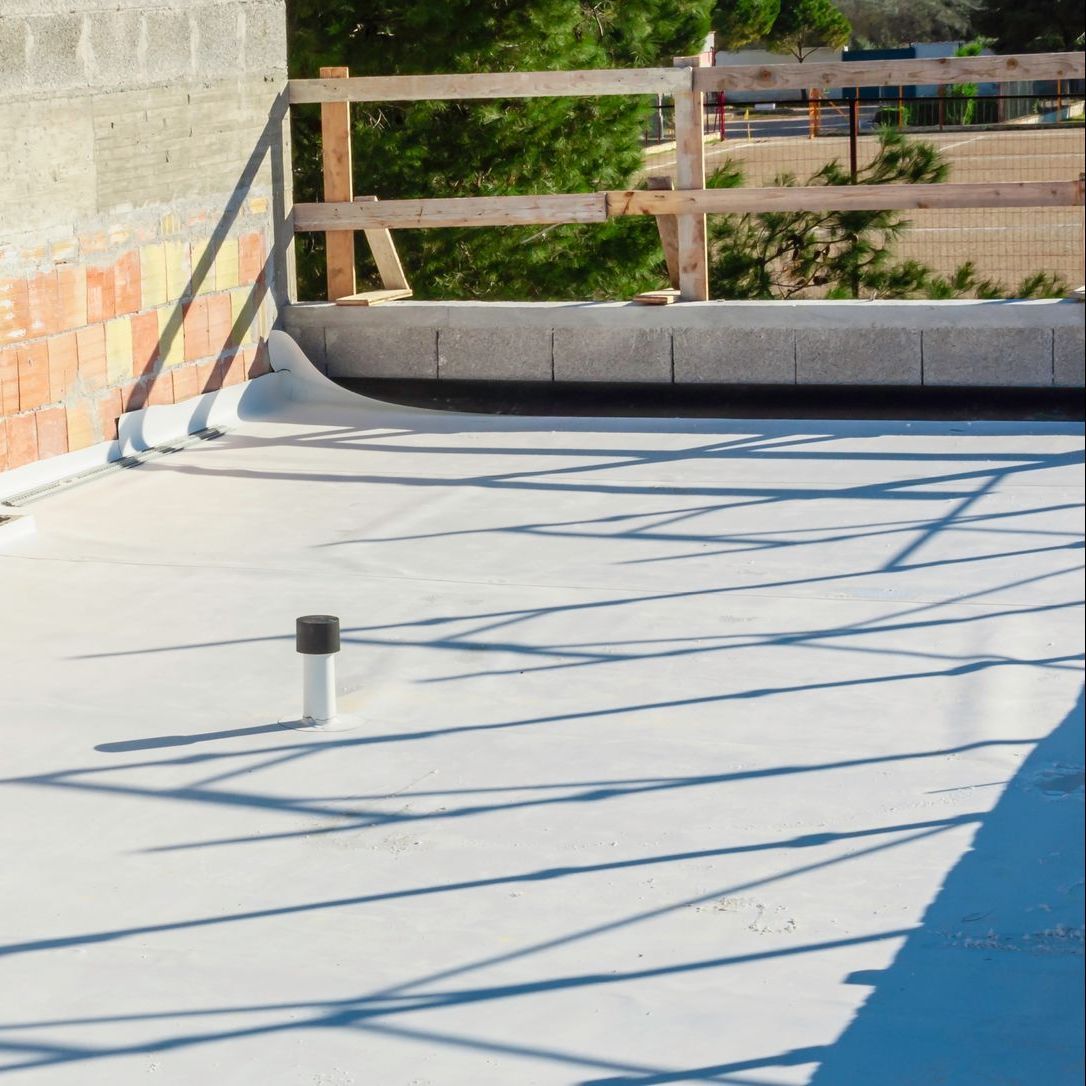 A flat white roof with a black pipe on it
