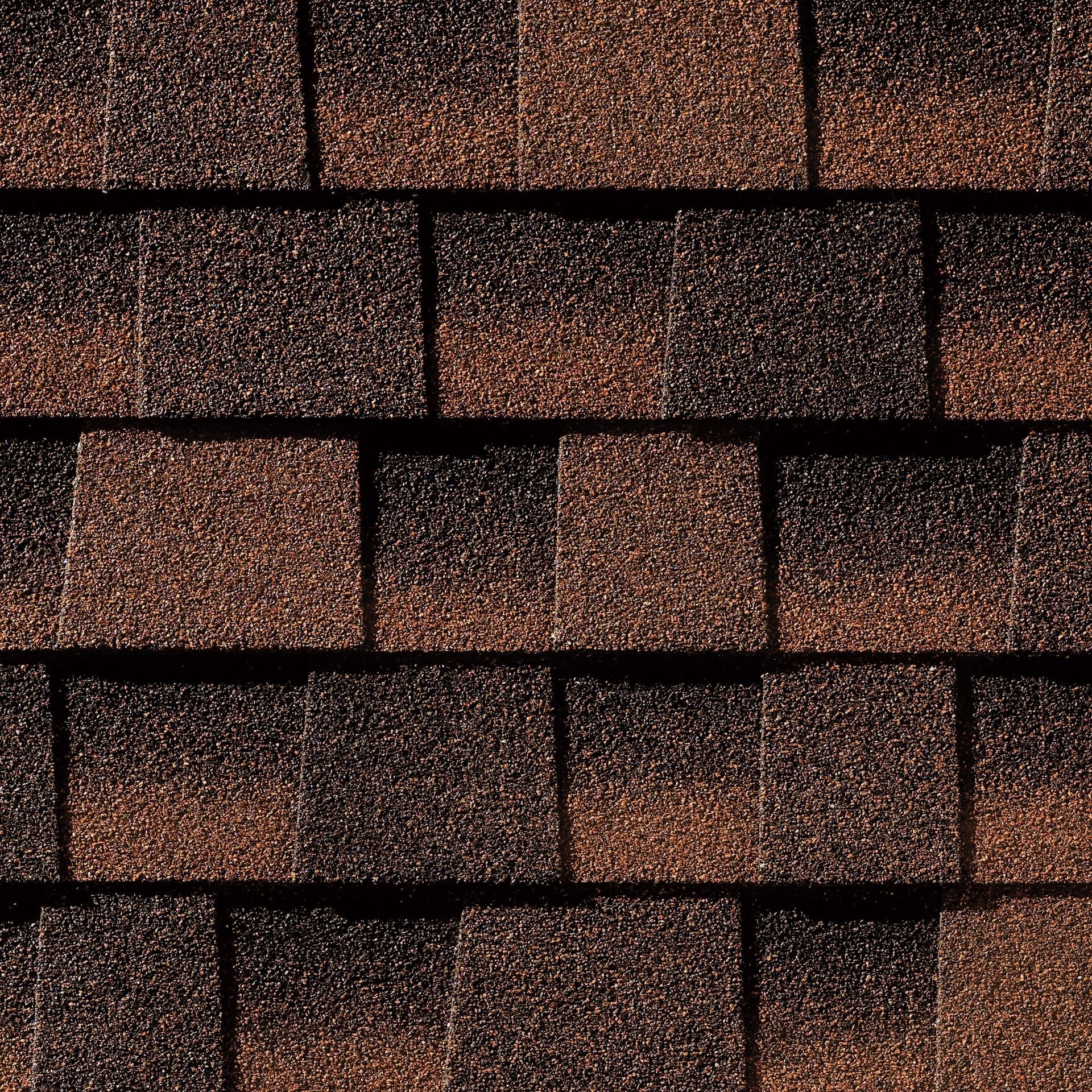 A close up of a row of brown shingles on a roof.